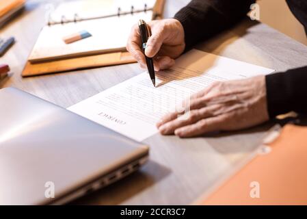 Senior businessman reviewing terms of contract at office Stock Photo