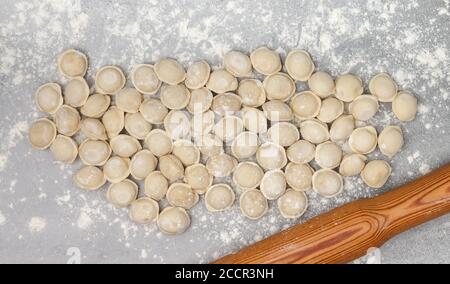 Fresh raw homemade handmade pelmeni (dumplings) with minced meat or fish. Home food concept. Selective focus, top view Stock Photo