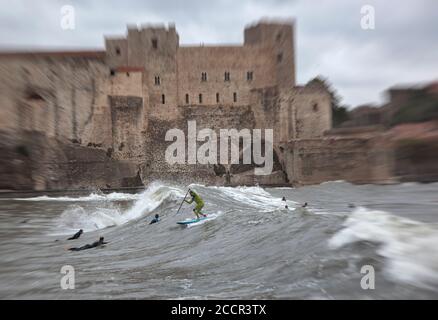 Surfers riding waves in Collioure harbour Stock Photo