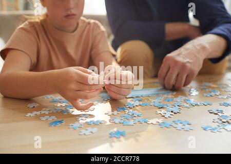 Warm toned close up of unrecognizable girl playing board games with grandparents while enjoying time together, copy space Stock Photo