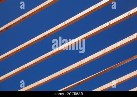 Wooden sunshade roof structure is under deep blue sky at sunny summer day Stock Photo
