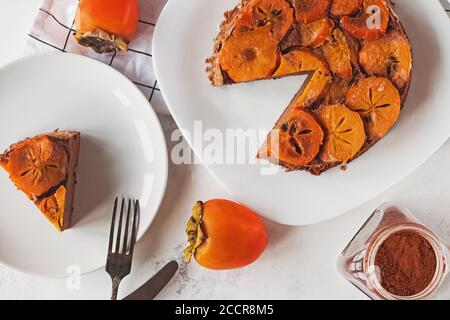 Homemade upside down persimmon cake on white table, top view Stock Photo