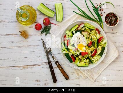 Fresh delicious salad of young cabbage with cucumber, radish, dill, green onions, spices and mustard dressing. Selective focus Stock Photo