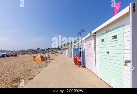 Beach huts along Marine Parade promenade in Lyme Regis, a popular seaside town holiday resort on the Jurassic Coast in Dorset, south-west England Stock Photo