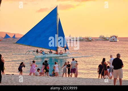 Boracay, Philippines - Jan 23, 2020: Sunset on Boracay island. Sailing and other traditional boats with tourists on the sea against the background of Stock Photo