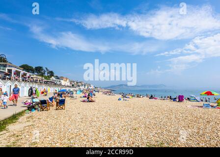 The stony beach and seafront in high season at Lyme Regis, a popular seaside holiday resort on the Jurassic Coast in Dorset, south-west England Stock Photo