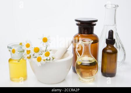 Oil for skin care, massage from natural ingredients, herbs in glass jars and test tubes on a white background Stock Photo