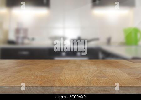 Wooden table, tabletop in the foreground with blurred kitchen interior background Stock Photo