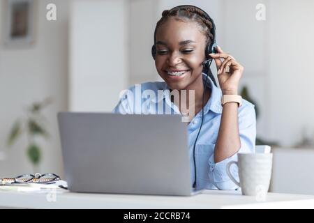 Customer Support. Black woman manager wearing headset and using laptop in office Stock Photo