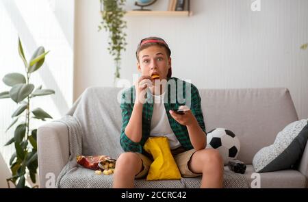 Surprised teenager football fan watching game on tv Stock Photo