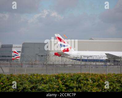 Heathrow Airport, London, UK. 24 August 2020. Tailfins of British Airways aircraft parked up at Heathrow airport. Credit: Malcolm Park/Alamy. Stock Photo