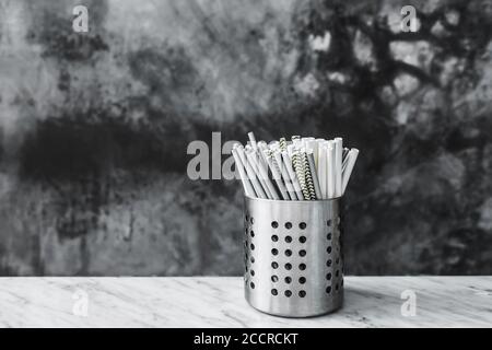 Set of different paper drinking straws on gray concrete background in cafe close-up. Recycling, plastic free and eco-friendly. Stop environmental pollution. Stock Photo
