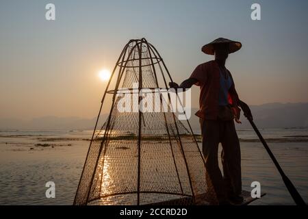 Intha traditional leg rowing fisherman on Inle lake at sunset, Burma, Myanmar Stock Photo