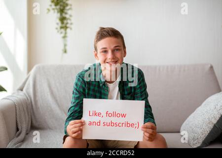 Teen blogger holding placard with like follow subscribe text Stock Photo