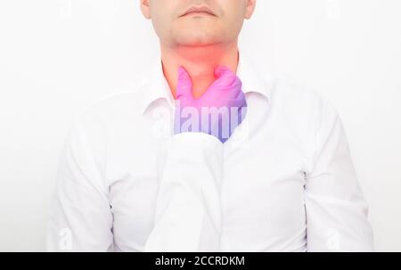 The doctor checks during the examination of the thyroid gland in a man on a white background. Concept of Thyroid Disease in Men, Nodular Goiter and Ca Stock Photo