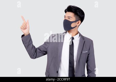 Portrait young asian businessman in suit wearing face mask for protective covid-19 isolated on white background, business man presenting and showing, Stock Photo
