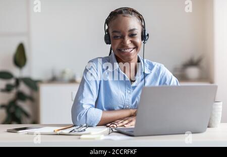 Portrait Of Smiling Black Woman Call Center Operator At Workplace In Office Stock Photo