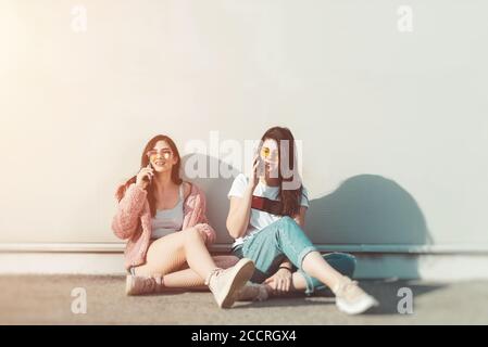 Two young women talking on their mobile phones Stock Photo