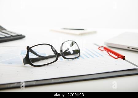 White office desk table with blank notebook, computer keyboard and other office supplies. Stock Photo