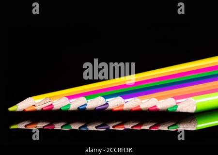Colorful pencils in a row on black background, copy space Stock Photo