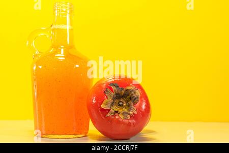 Persimmon juice (Diospyros kaki L.). Fruit juice in a glass bottle. Fresh fruits. Detox and natural drink. Tropical fruit drink. Refreshing drink rich Stock Photo