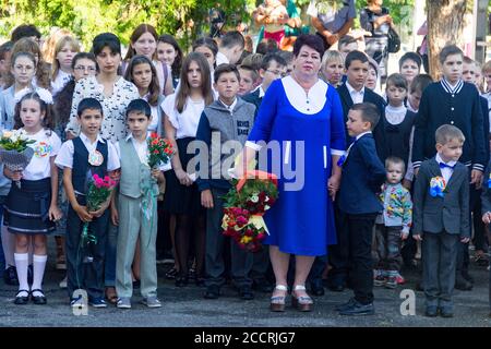 Adygea, Russia - September 1, 2017: children with bouquets flowers enrolled in the first class at school with teachers and high school students at the Stock Photo