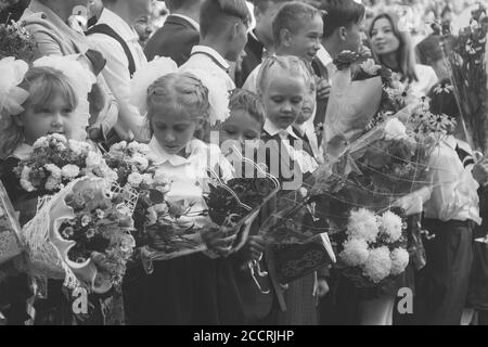 Adygea, Russia - September 1, 2017: children with bouquets of flowers enrolled in the first class with high school students on the school line in the Stock Photo