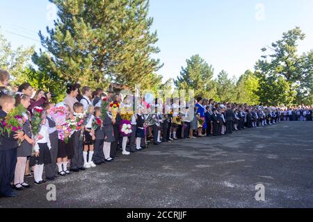 Adygea, Russia - September 1, 2017: children with bouquets of flowers enrolled in the first grade in school with teachers and pupils on a solemn ruler Stock Photo