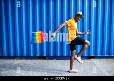 Young black man with rainbow bag walking, black lives matter concept. Stock Photo