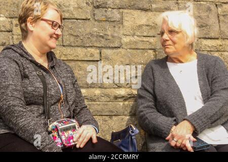 Women chatting on a bench Stock Photo