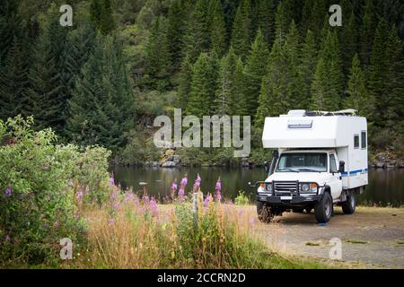 A large four wheel drive camper car parked nearby the water in beautiful nature. Location is Lofoten Islands, Norway. Stock Photo