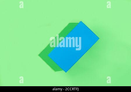 Blue geometric figure, a rectangular with shadows on a light green background. Stock Photo