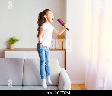 Asian Girl Singing Song Having Fun With Hairbrush At Home Stock Photo