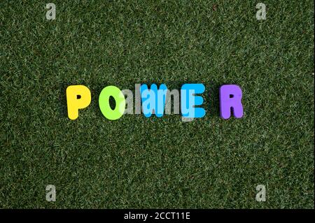 Power spelt out on green grass background with colourful letters Stock Photo