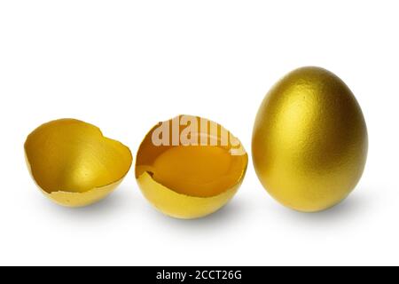 Golden eggs and half broken egg with yolk isolated at the white background Stock Photo