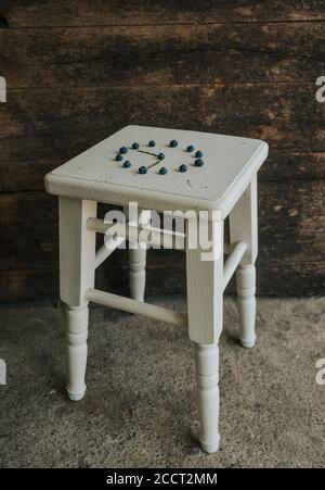 on wooden white chairs lie berries folded in a circle in the shape of a clock Stock Photo