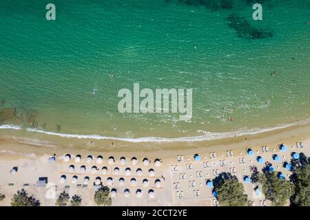 Kea Tzia island, Cyclades, Greece. Aerial drone view of Otzias beach a summer sunny day. Sandy beach with umbrellas and deck chairs, people swimming i Stock Photo