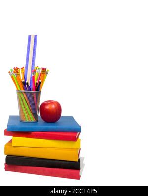 Vertical shot of a stack of colorful books with an apple and a wire pencil holder sitting on top.  Pencil holder is holding pencils and a ruler.  Isol Stock Photo