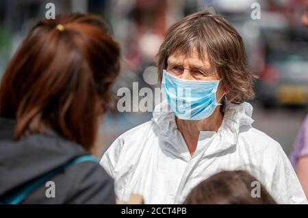 Extinction Rebellion member interacts with a passer-by outside Barclays. XR continue to protest the banks continued investments in fossil fuels. UK Stock Photo