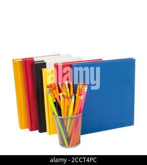 Vertical shot of a group of colorful books standing up with a wire pencil holder in front full of pencils.  White background.  Copy space. Stock Photo