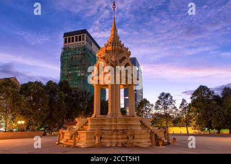 The Yeay Penh Statue near Wat Phnom in Phnom Penh, Cambodia, with high rise apartments behind Stock Photo