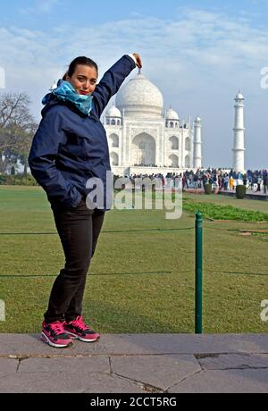 Agra, Uttar Pradesh, India. A young woman pretends to take the Taj Mahal in hand Stock Photo