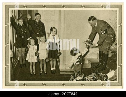 German historical postcard: Adolf Hitler's 50th Birthday. He receives a bouquet of flowers from the youngest of Goebbels ' 6 children, Germany, 1939 Stock Photo