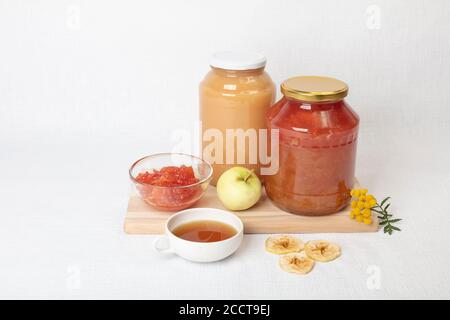 Apple jam and juice, fresh and dried apples, flowers, tea in a cup, still life, home concept, natural products. High quality photo Stock Photo