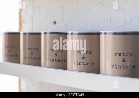 Vintage beige tea and coffee mugs on wooden white shelf, selective focus Stock Photo