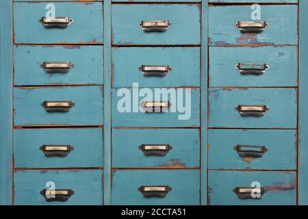 Old turquoise and brown colored wooden cabinet with drawers background Stock Photo