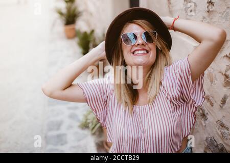 Young attractive smiling blond woman with hat joyfully Stock Photo