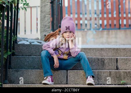 portrait of a young girl sat on a step with attitude waiting Stock Photo