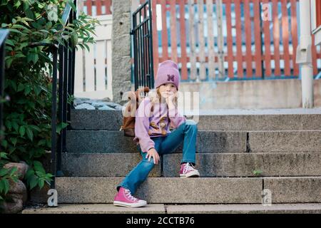 portrait of a young girl sat waiting for school Stock Photo