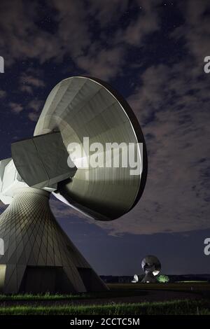 The dish antennas in the city of Raisting, Germany under a cloudy night sky Stock Photo